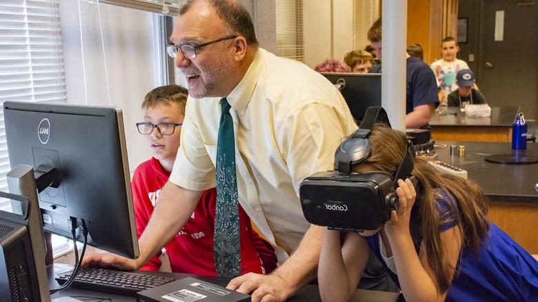 Michael Gallis帮助尝试VR头显的中学生.